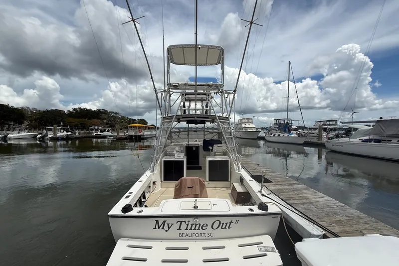 Slide: The Image of 2002 Carolina Classic 28 boat docked at marina under cloudy sky. - 3