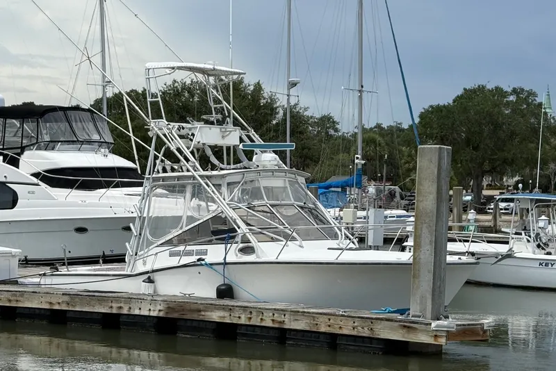 Slide: The Image of 2002 Carolina Classic 28 boat docked at a marina with other vessels. - 4