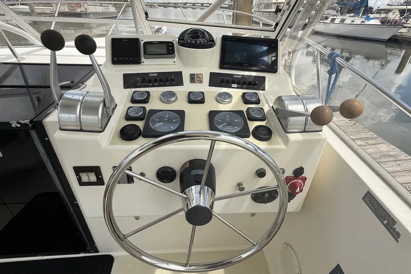 Slide: The Image of Helm of 2002 Carolina Classic 28 boat with steering wheel and control panel. - 8