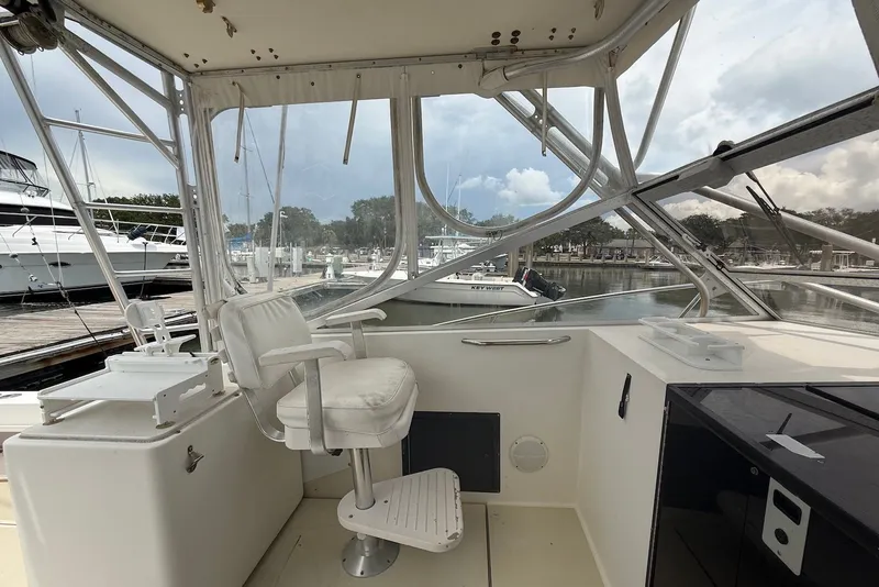 Slide: The Image of 2002 Carolina Classic 28 boat cockpit with white captain's chair and marina view. - 12