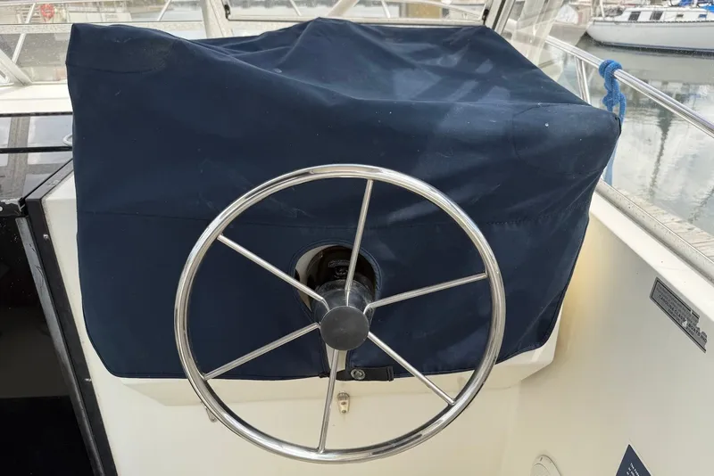 Slide: The Image of Steering wheel of a 2002 Carolina Classic 28 boat, covered with a navy blue fabric. - 14