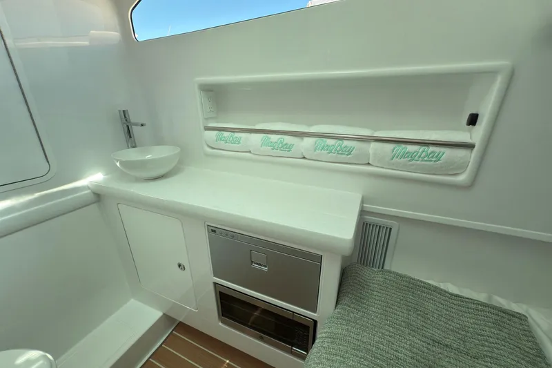 Slide: The Image of Manufacturer Provided Image: Interior of 2025 Mag Bay 38 CC boat with modern amenities and branded towels. - 4