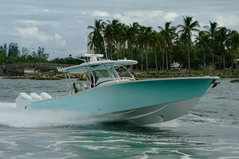 Slide: The Image of Manufacturer Provided Image: 2025 Mag Bay 38 CC boat cruising on water with palm trees in background. - 1
