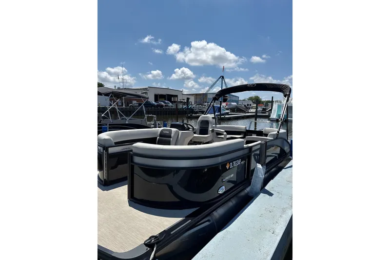 The Image of 2024 Harris Breeze 230 pontoon boat docked under a clear blue sky. - 1