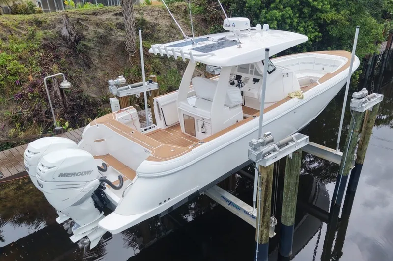 Slide: The Image of Intrepid 345 Nomad SE 2022 on a boat lift above the water. - 1