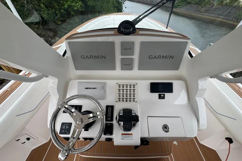 Slide: The Image of 2022 Intrepid 345 Nomad SE helm with Garmin displays and Mercury controls. - 7