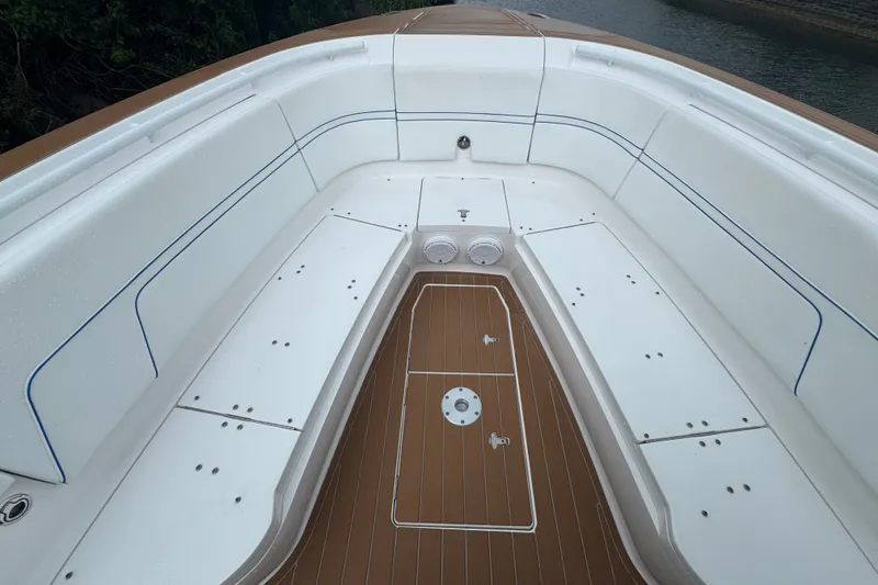 Slide: The Image of 2022 Intrepid 345 Nomad SE boat interior with white seating and brown deck. - 20