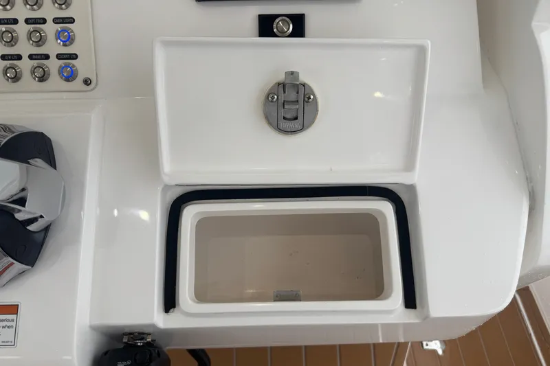 Slide: The Image of Control panel and storage compartment on 2022 Intrepid 345 Nomad SE boat. - 42