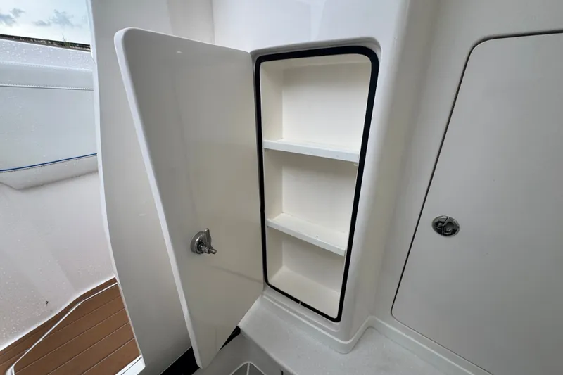 Slide: The Image of Open storage compartment on 2022 Intrepid 345 Nomad SE boat, showcasing interior shelves. - 31