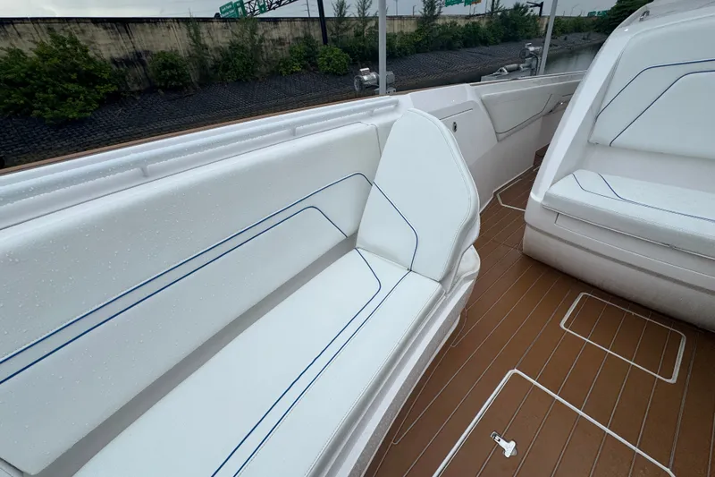 Slide: The Image of 2022 Intrepid 345 Nomad SE boat interior with white seating and teak flooring. - 18