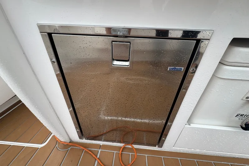 Slide: The Image of Stainless steel hatch on 2022 Intrepid 345 Nomad SE boat, with water droplets and orange cable. - 26