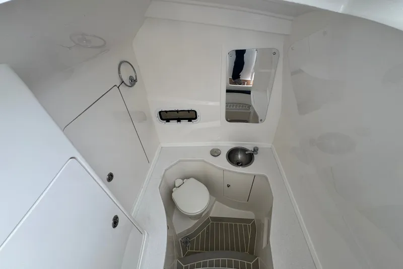 Slide: The Image of 2022 Intrepid 345 Nomad SE boat bathroom with sink, toilet, and mirror. - 29