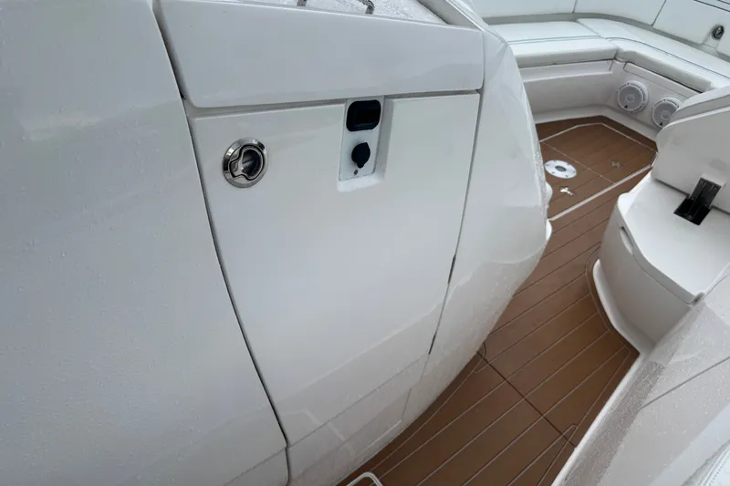 Slide: The Image of 2022 Intrepid 345 Nomad SE boat interior with sleek white design and brown flooring. - 28