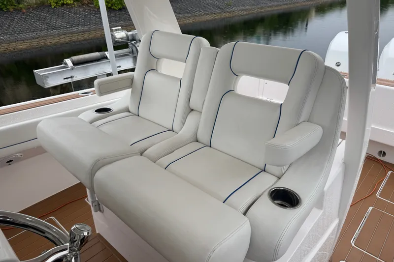 Slide: The Image of Luxury seating on 2022 Intrepid 345 Nomad SE boat, featuring plush white upholstery. - 17