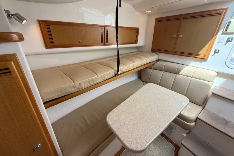 Slide: The Image of 2007 Cabo 32 Express cabin interior with beige seating and wooden cabinets. - 62