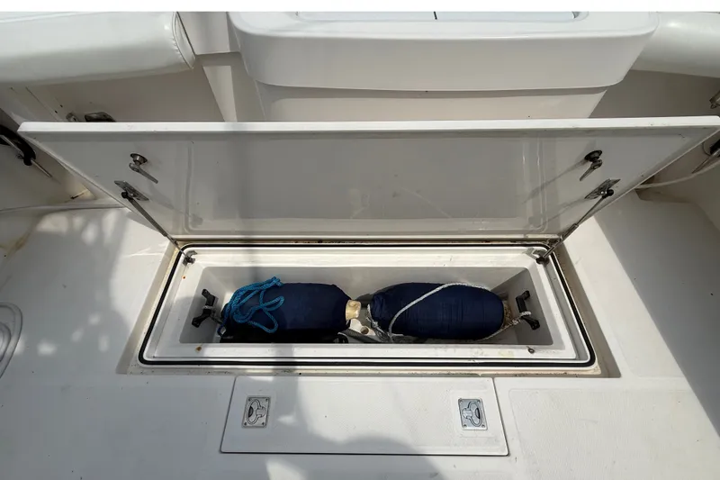 Slide: The Image of An open storage compartment on a 2007 Cabo 32 Express boat reveals two fenders. - 22
