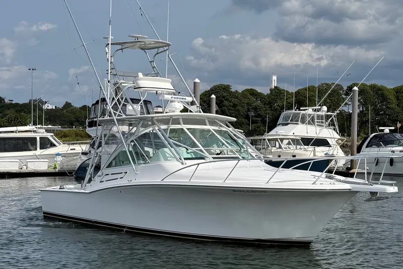 Slide: The Image of 2007 Cabo 32 Express boat docked in marina, surrounded by other vessels. - 8