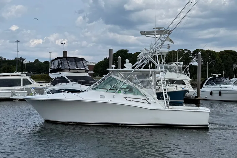 Slide: The Image of 2007 Cabo 32 Express boat docked in a marina under cloudy skies. - 7