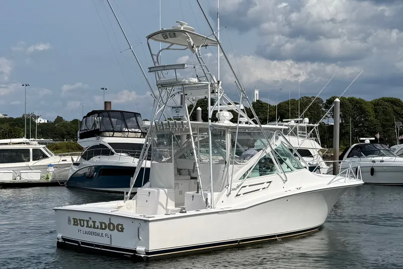 Slide: The Image of 2007 Cabo 32 Express boat docked in marina, clear sky, surrounded by other vessels. - 10