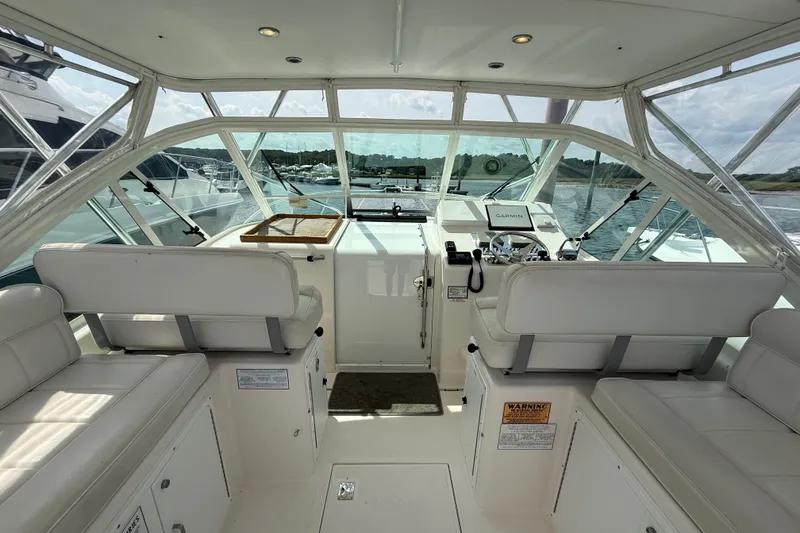 Slide: The Image of Interior view of 2007 Cabo 32 Express boat cockpit with white seating and navigation equipment. - 25