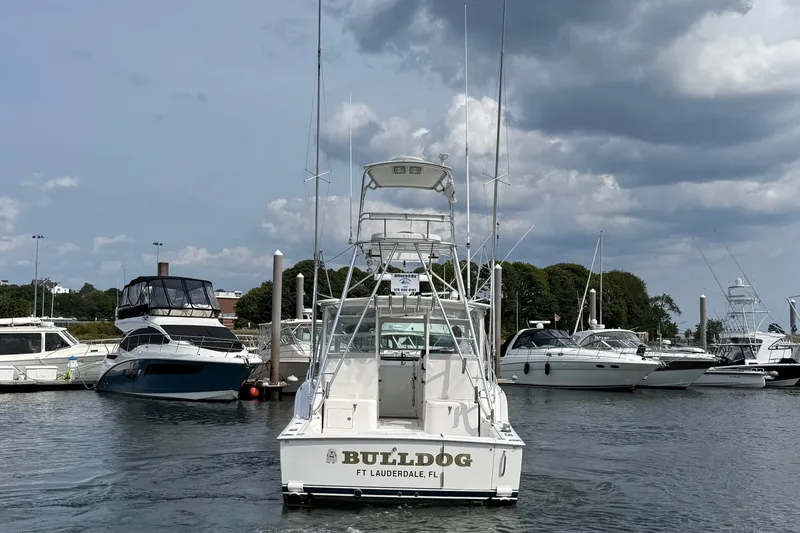 Slide: The Image of 2007 Cabo 32 Express boat named "Bulldog" docked in a marina under cloudy skies. - 11