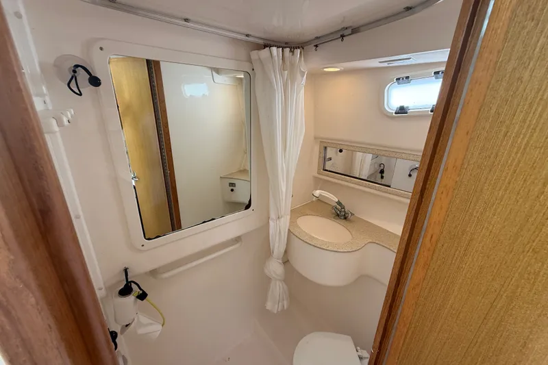 Slide: The Image of Bathroom interior of 2007 Cabo 32 Express boat with sink, mirror, and window. - 67