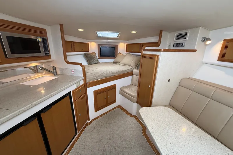 Slide: The Image of Interior of 2007 Cabo 32 Express boat with kitchenette, bed, and seating area. - 59