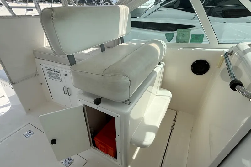 Slide: The Image of 2007 Cabo 32 Express boat interior with white seating and storage compartment. - 47