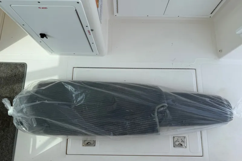 Slide: The Image of Plastic-wrapped item on 2007 Cabo 32 Express boat deck, near storage compartment. - 49