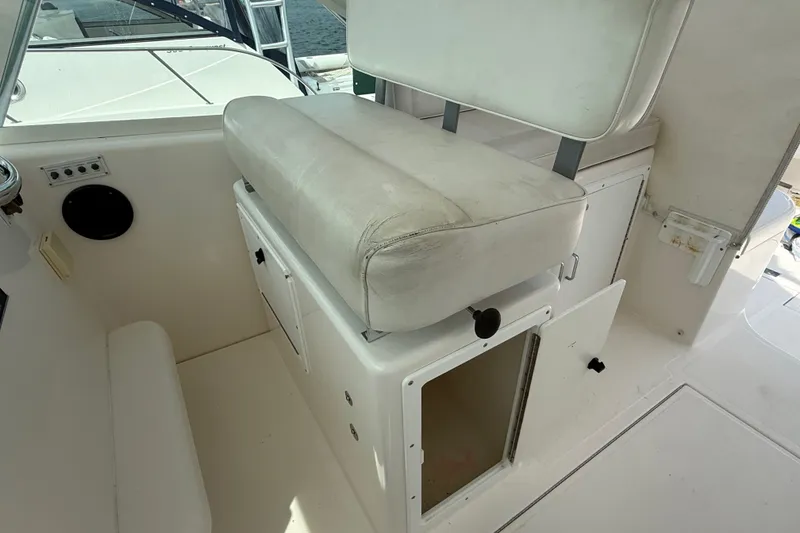 Slide: The Image of 2007 Cabo 32 Express boat interior with white cushioned seating and storage compartments. - 46