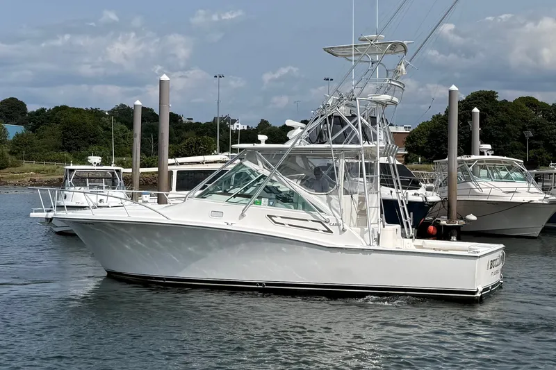 Slide: The Image of 2007 Cabo 32 Express boat docked in a marina, surrounded by other vessels. - 12