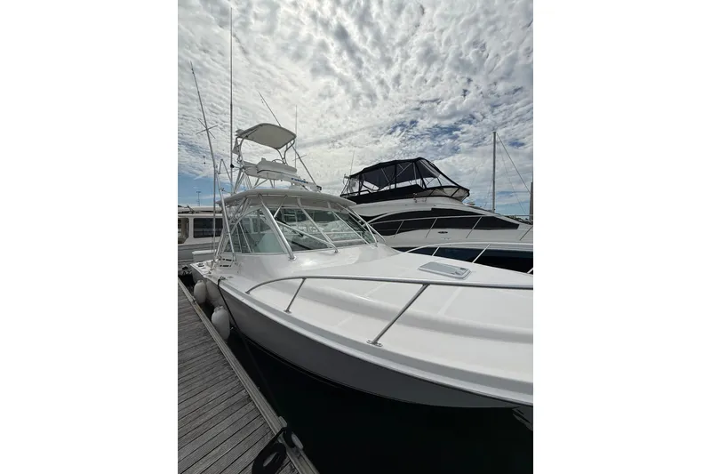 Slide: The Image of 2007 Cabo 32 Express boat docked under a cloudy sky. - 16