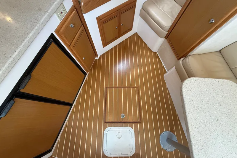 Slide: The Image of Interior of 2007 Cabo 32 Express boat with wood paneling and beige seating. - 68