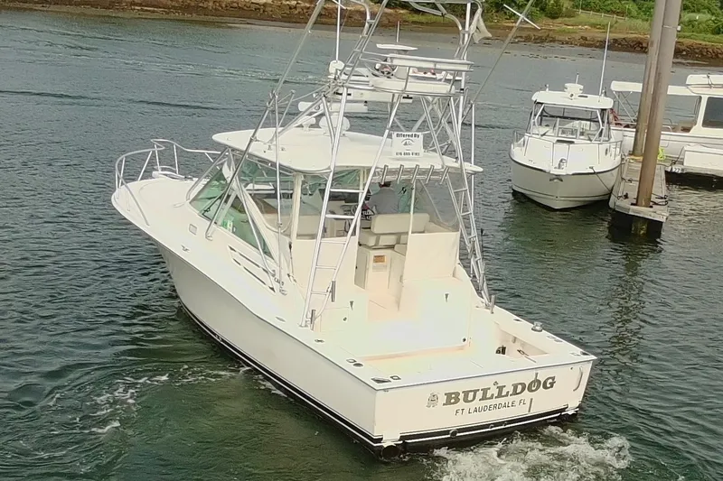 Slide: The Image of 2007 Cabo 32 Express boat named "Bulldog" cruising in a marina. - 4