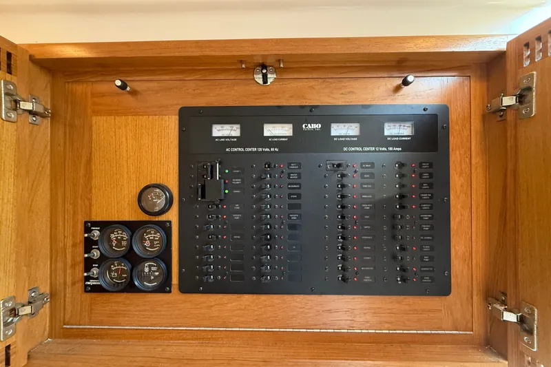 Slide: The Image of Electrical control panel of a 2007 Cabo 32 Express boat, featuring gauges and switches. - 70
