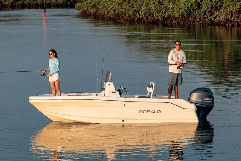 Slide: The Image of Manufacturer Provided Image: 2026 Robalo R160 Center Console boat with two people fishing on calm water. - 1