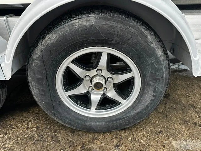 Slide: The Image of Close-up of a boat trailer wheel with a silver rim and black tire. - 9