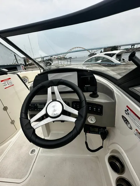 Slide: The Image of The image shows the cockpit of a 2021 Stingray 231 boat with a modern steering wheel and instruments. - 18