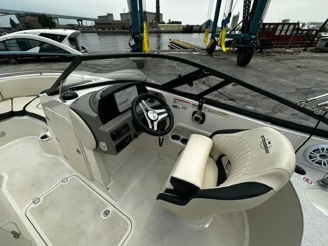 Slide: The Image of The image shows the cockpit of a 2021 Stingray 231 boat with a sleek steering wheel and comfortable seat. - 17