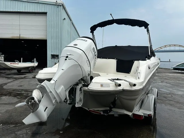 Slide: The Image of A 2021 Stingray 231 boat with an outboard motor, on a trailer in front of a warehouse. - 3