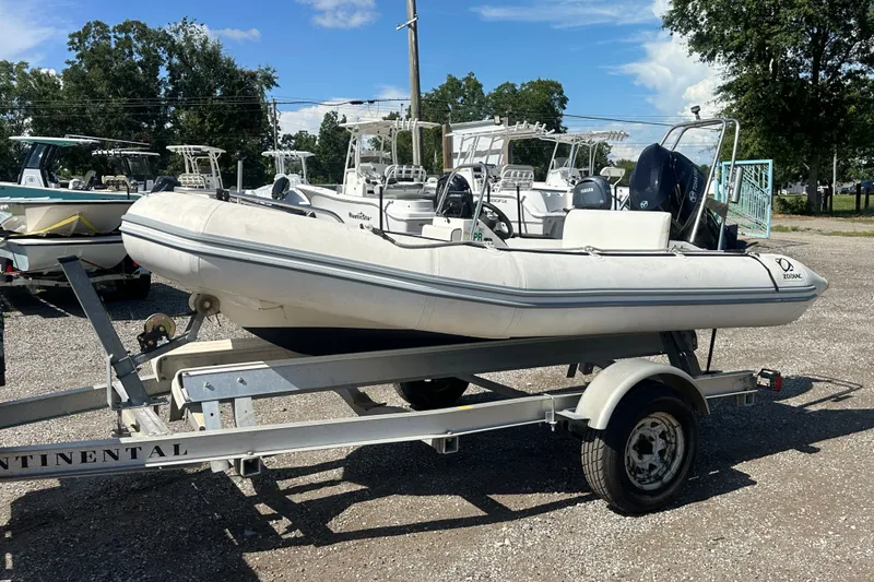 Slide: The Image of 1997 Zodiac Pro 420 inflatable boat on trailer, parked outdoors under clear sky. - 2