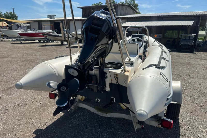 Slide: The Image of 1997 Zodiac Pro 420 inflatable boat with outboard motor, parked on a trailer. - 6