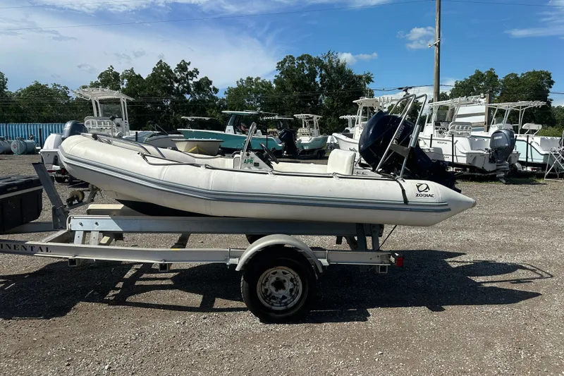 Slide: The Image of 1997 Zodiac Pro 420 inflatable boat on trailer, parked outdoors with other boats. - 3