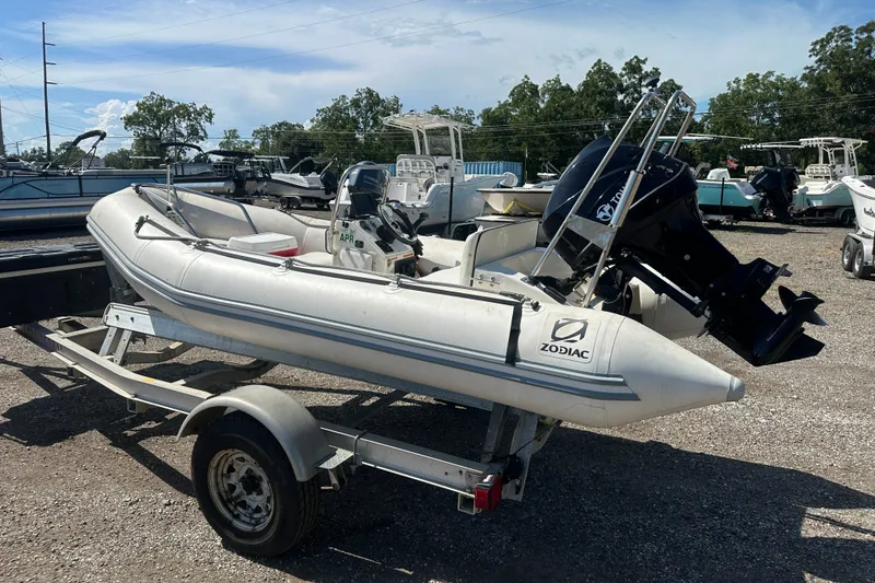 Slide: The Image of 1997 Zodiac Pro 420 inflatable boat on trailer, parked outdoors under clear sky. - 4