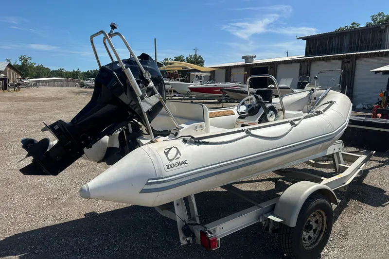 Slide: The Image of 1997 Zodiac Pro 420 inflatable boat on trailer, parked outdoors under clear blue sky. - 7