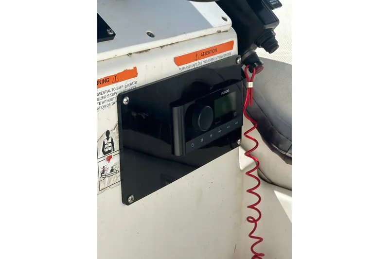 Slide: The Image of Control panel of a 1997 Zodiac Pro 420 boat with safety warnings and red coiled cord. - 16