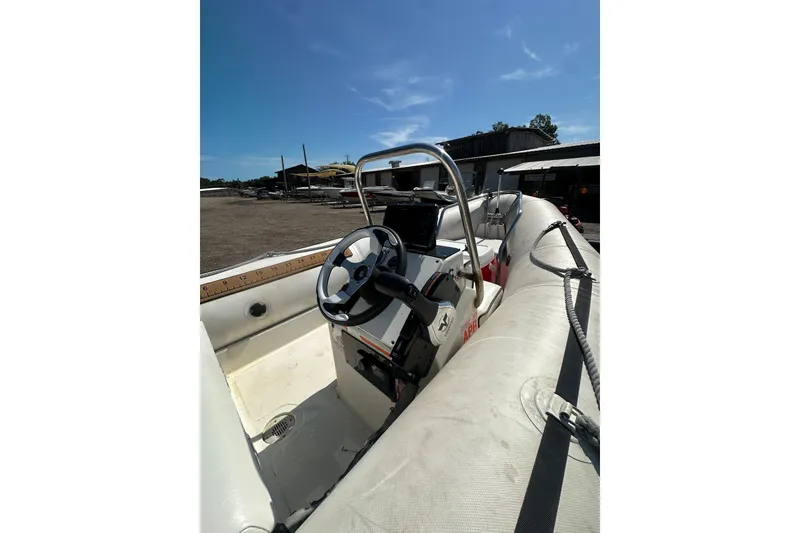 Slide: The Image of 1997 Zodiac Pro 420 boat interior with steering wheel, docked under clear blue sky. - 12