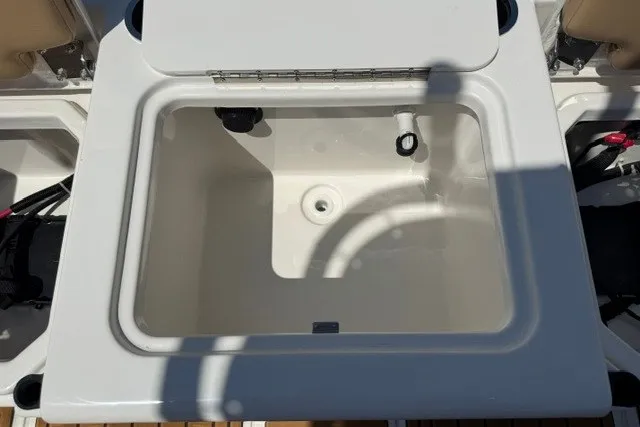 Slide: The Image of 2027 Bayliner Trophy T20CC boat storage compartment, open lid, white interior. - 17