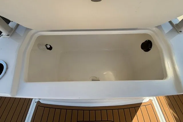 Slide: The Image of Open storage compartment on 2027 Bayliner Trophy T20CC boat with teak flooring. - 18