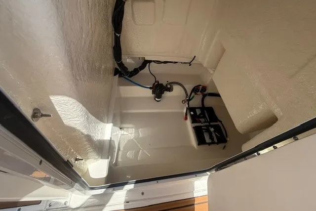 Slide: The Image of 2027 Bayliner Trophy T20CC interior compartment with wiring and battery setup. - 15